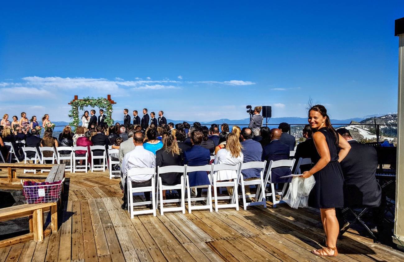 Wedding Planner in the background of a summer wedding ceremony at Squaw Valley's High Camp Venue in Lake Tahoe