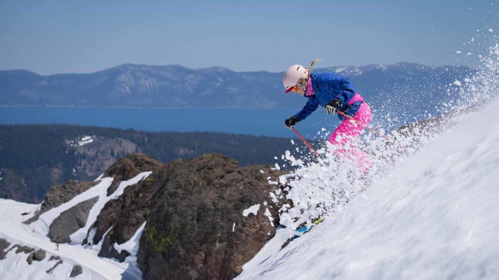 A skier rips some spring corn snow while getting a beautiful view of Lake Tahoe.