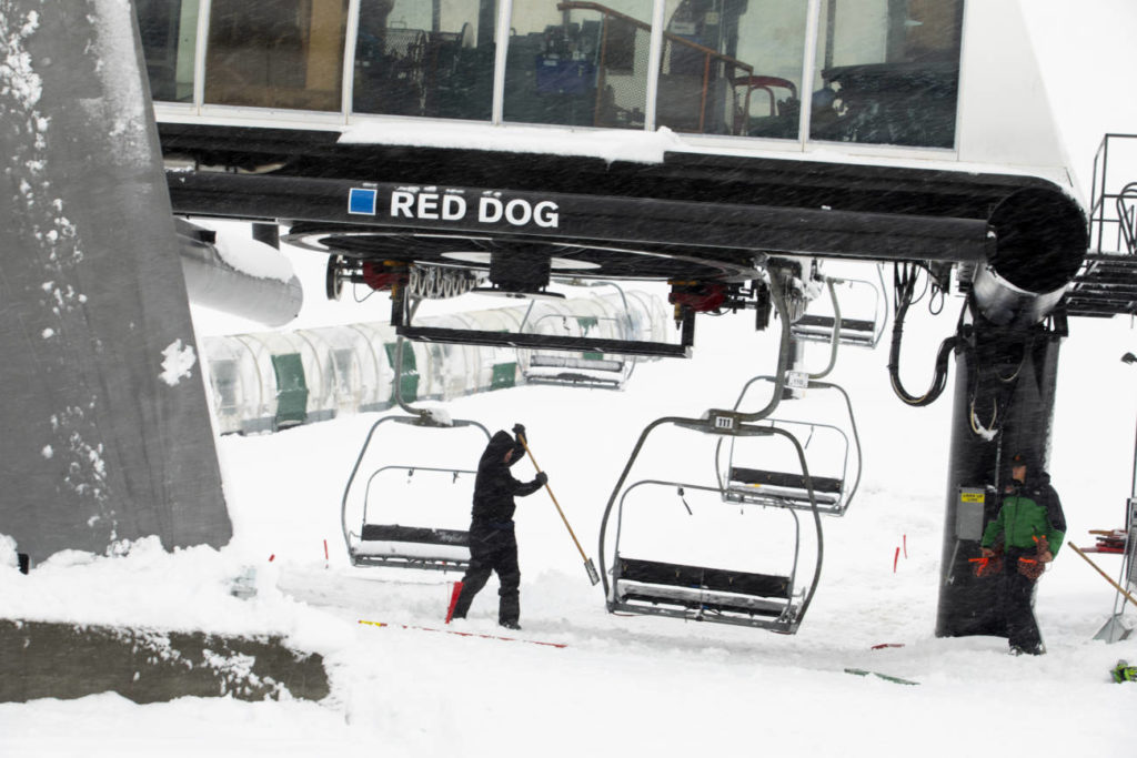 A lift operator clearing Red Dog on a snowy day at Palisades Tahoe.