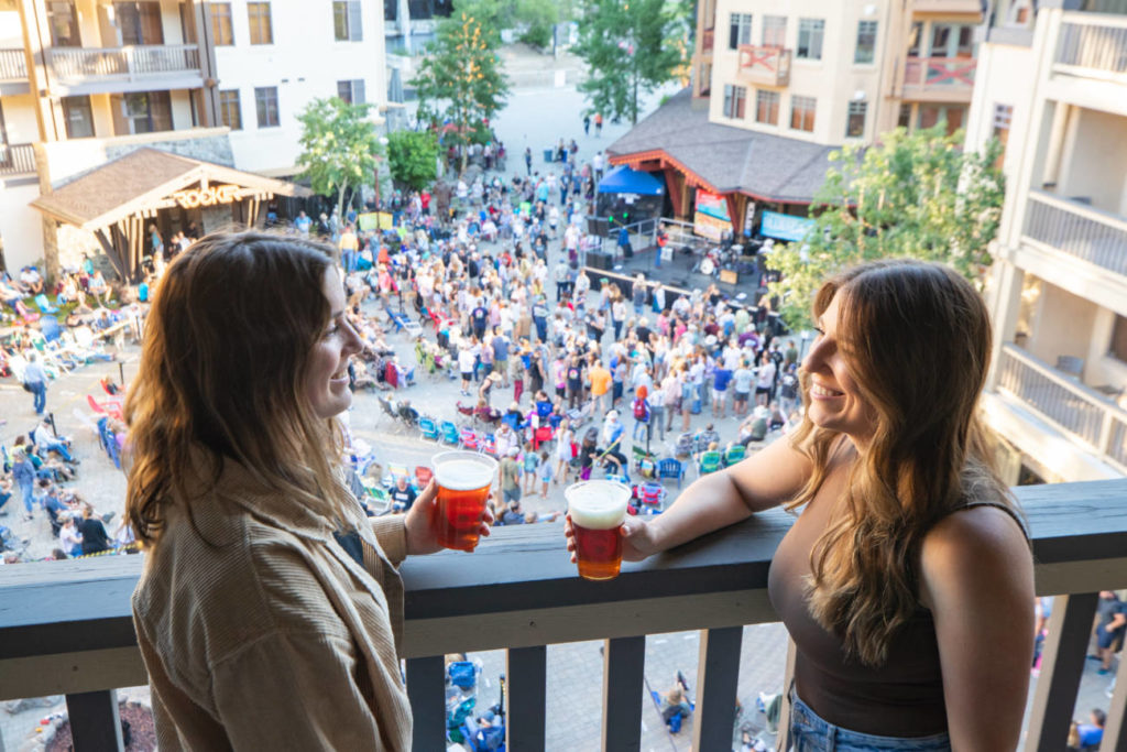 Two girls enjoying beer from a balcony while enjoying Bluesdays.