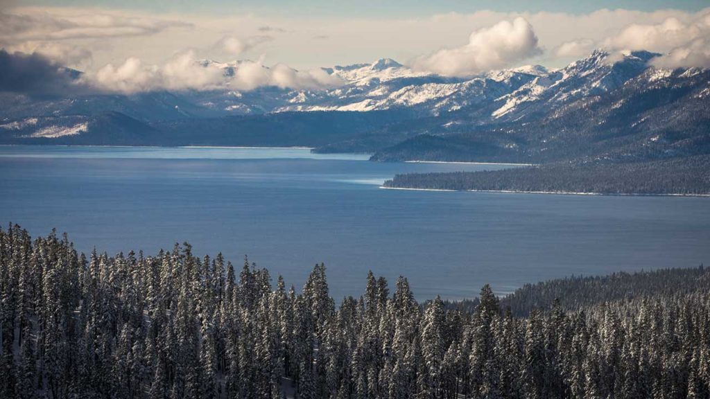 A scenic shot of Lake Tahoe and the surrounding mountains in the wintertime. 