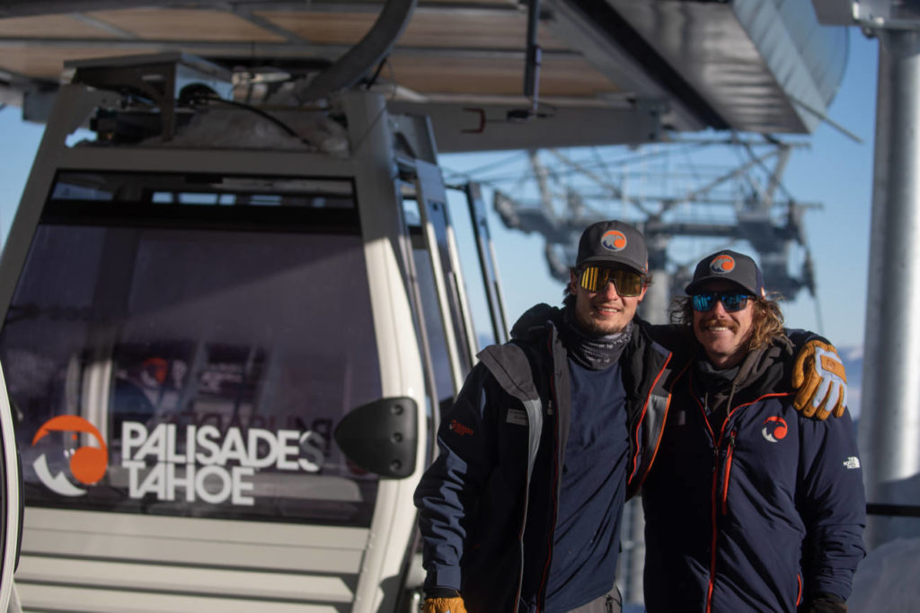 Two employees outside the Base to Base Gondola.