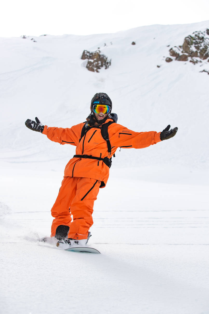 A snowboarder celebrates a great powder run.