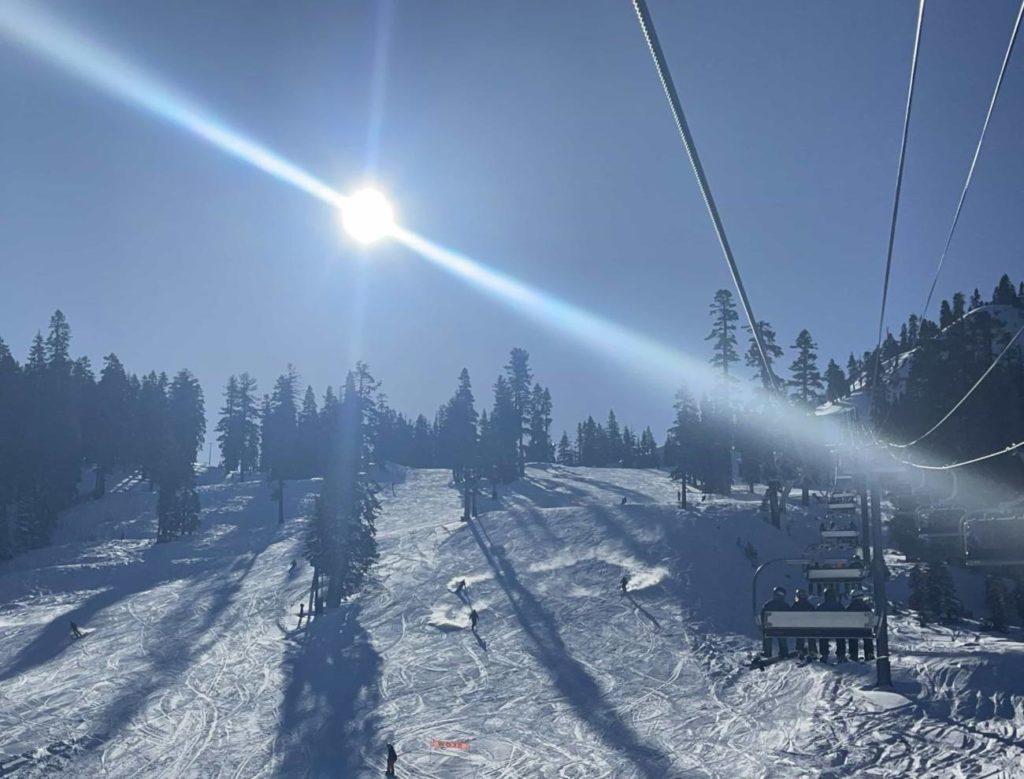 Chairlift ride with the sun shining in the bluebird sky