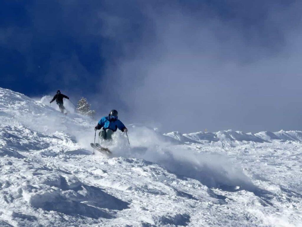 Skiers in fresh powder snow East Face blue skies