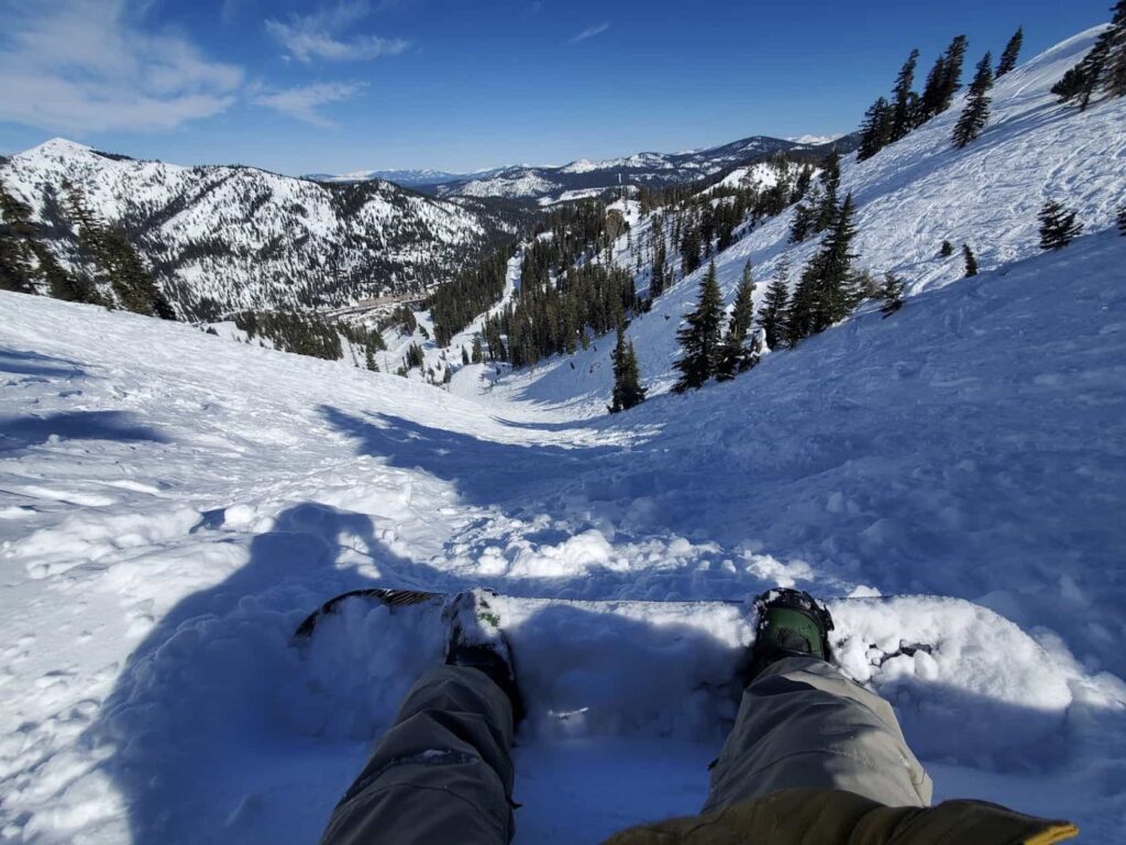 snowboarder sat on snow looking down slope