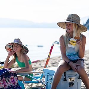 Two girls enjoy snacks on Lake Tahoe. 
