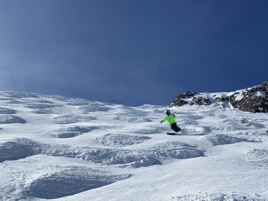 skier coming down snowy moguls