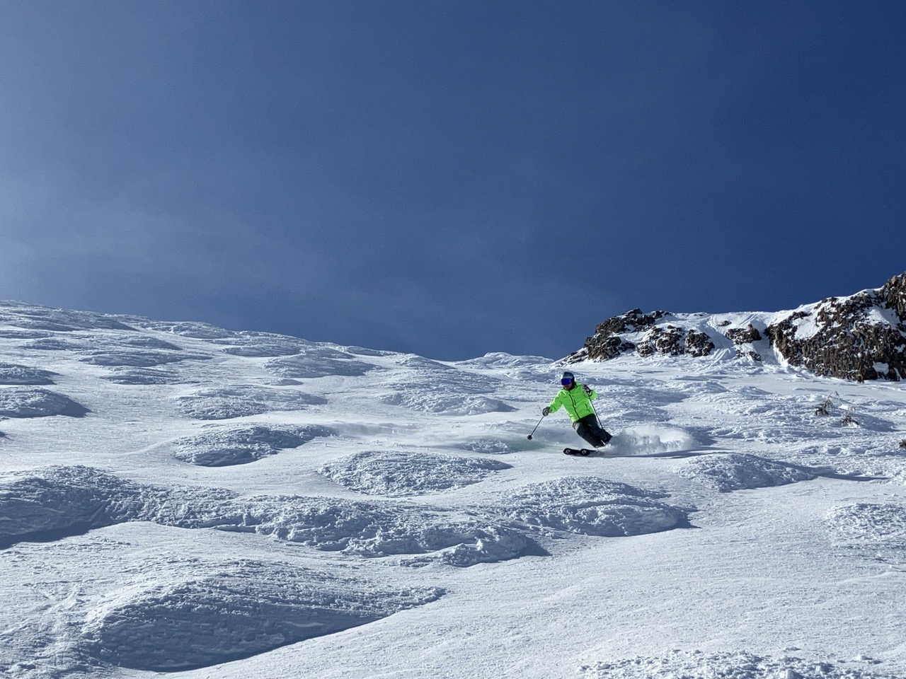 skier coming down snowy moguls