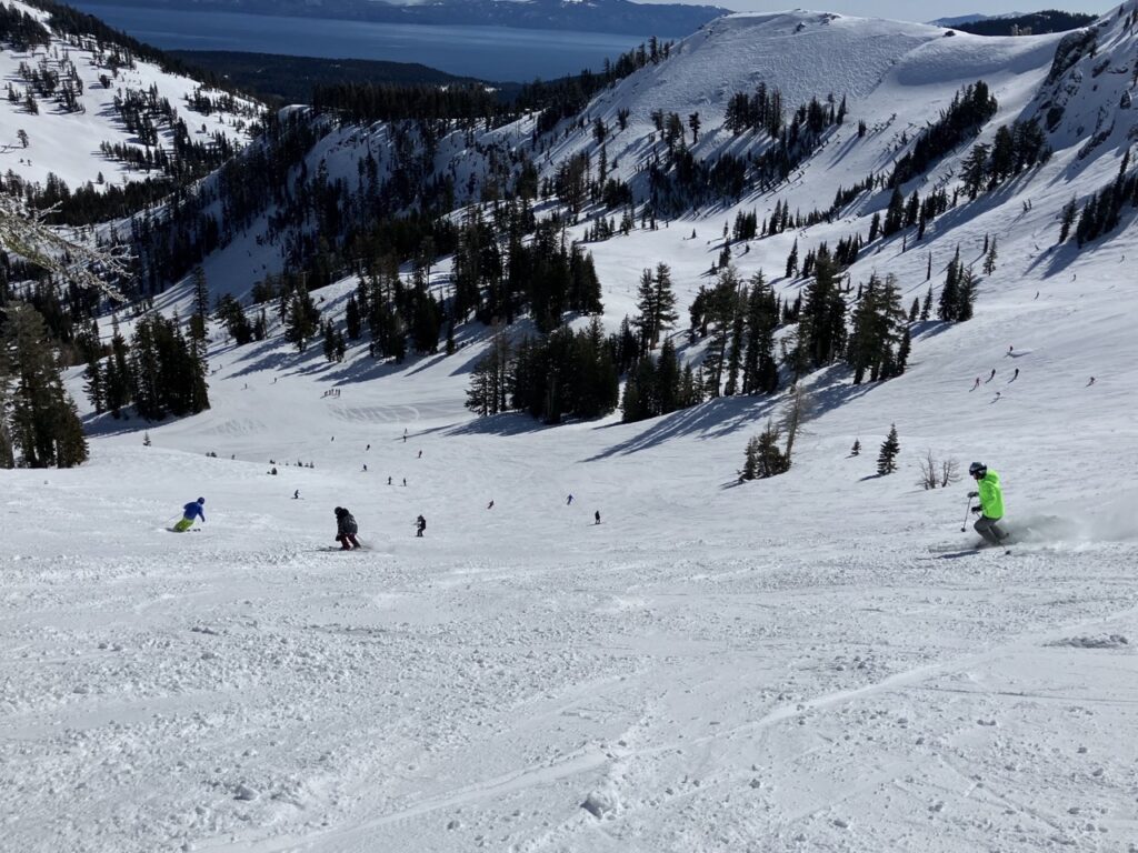 View down snowy slope towards Lake Tahoe