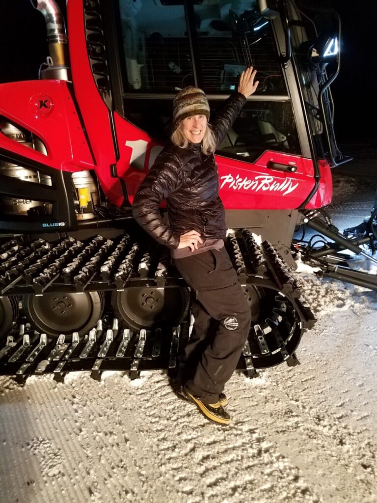 Palisades Tahoe athletic trainer Alby stands with a PistenBully snowcat.