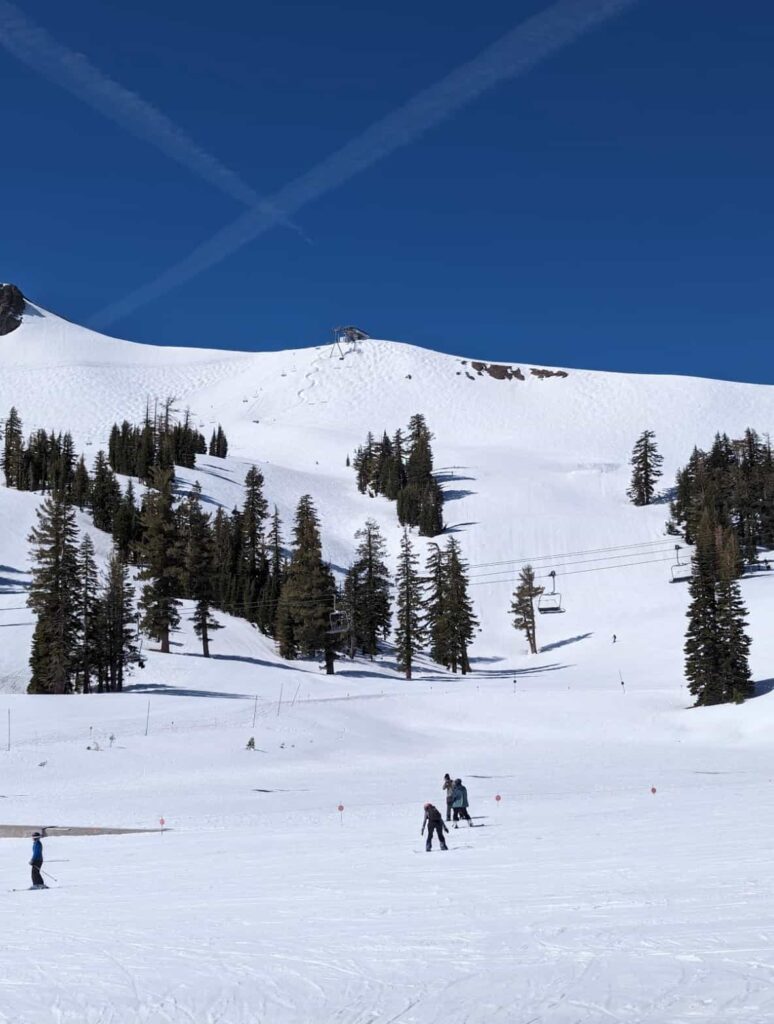 snowy mountain ski resort with blue skies and trees