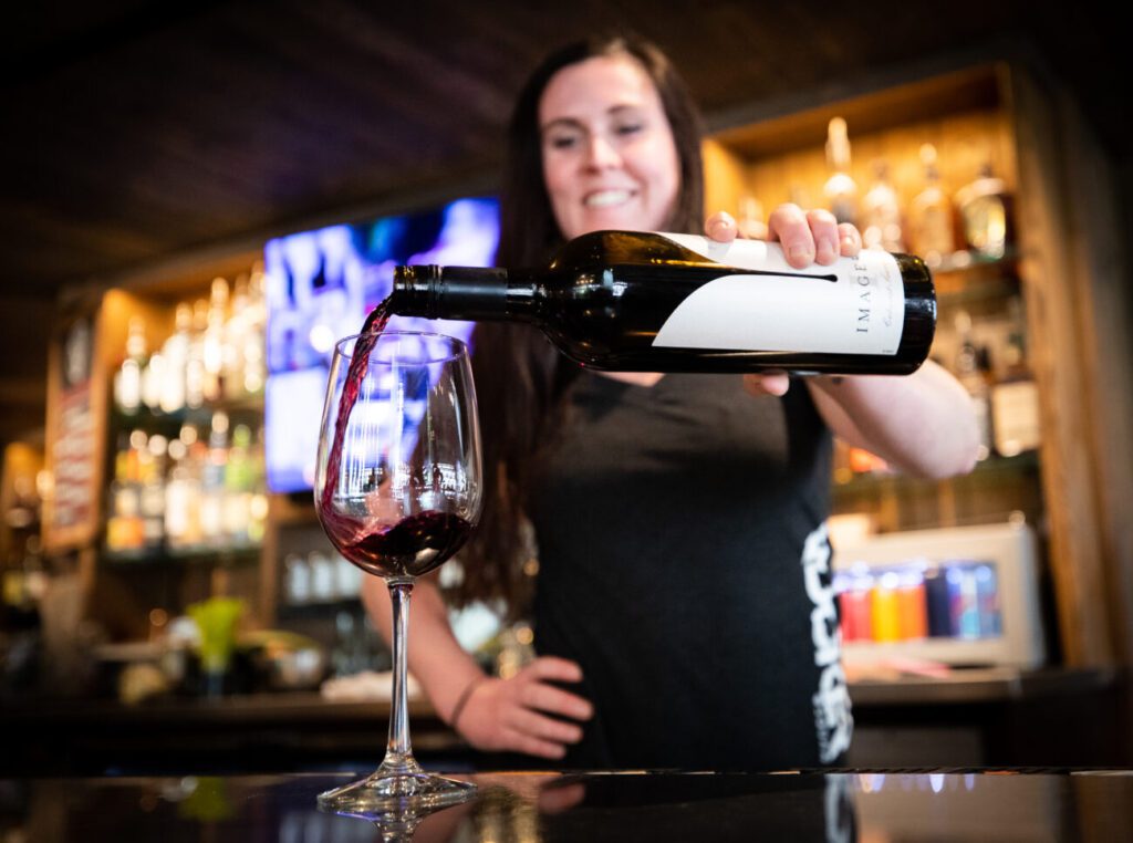 Lady pouring a glass of wine at Rocker