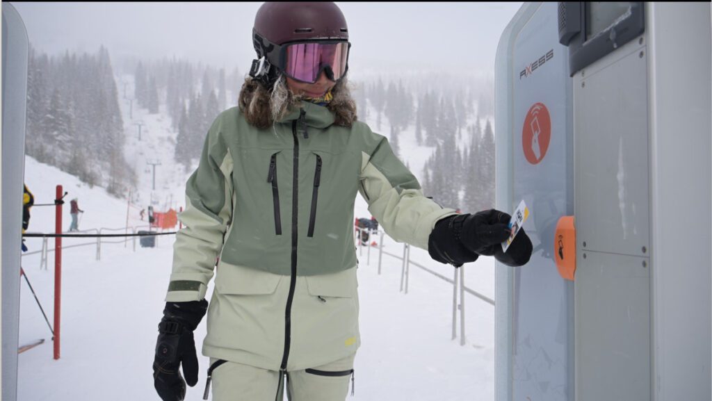 Snowboarder scanning pass at the bottom of a lift