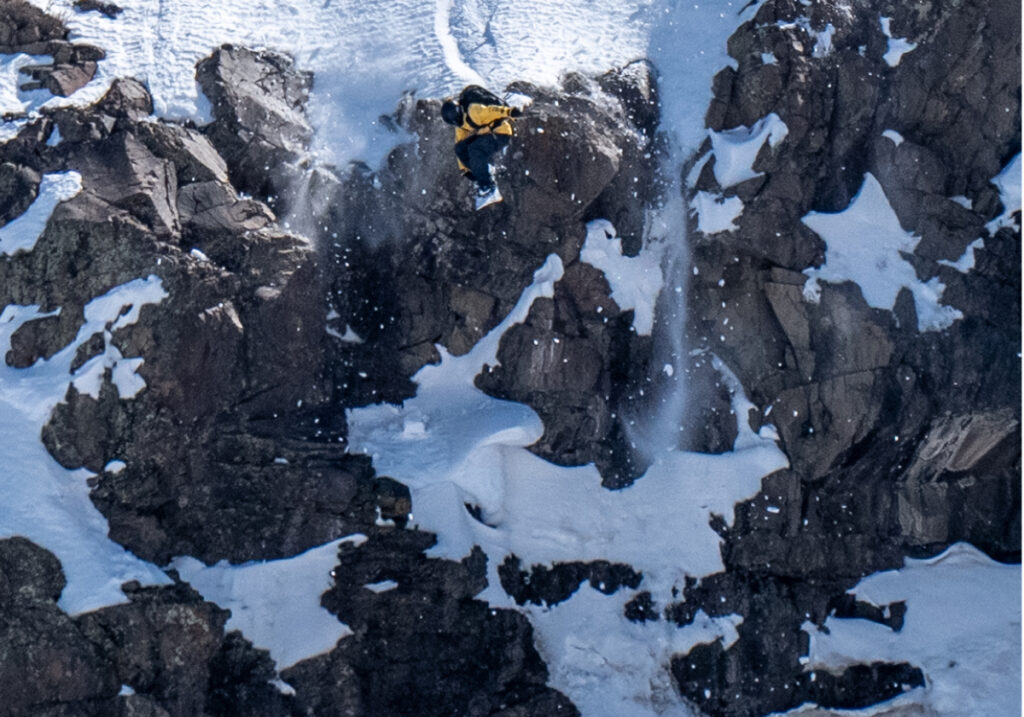 Tilden Wooley jumps off a cliff with his snowboard