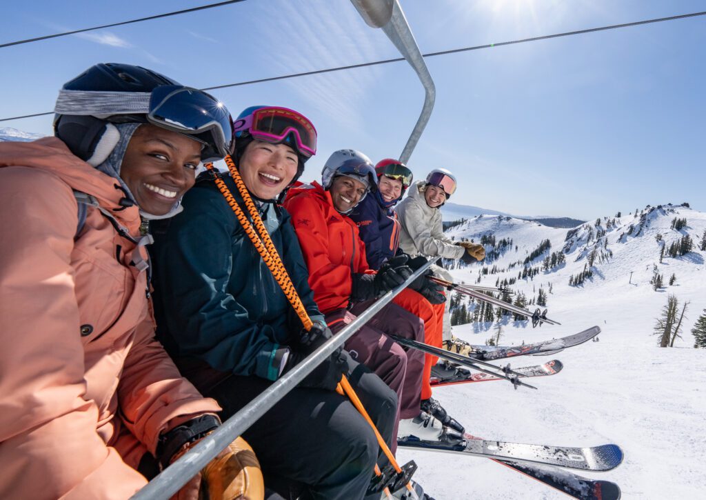 Group of gals including Amie Engerbretson smiling on a chairlift