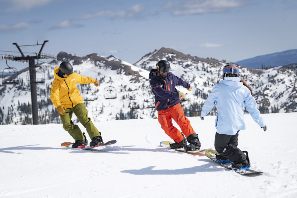 Two snowboarders during a beginners lesson