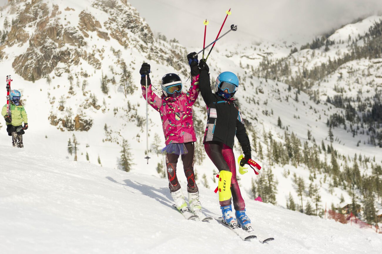 Two girl ski racers ready to drop in