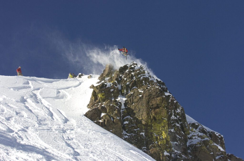 Skier hitting cliff off of Emigrant