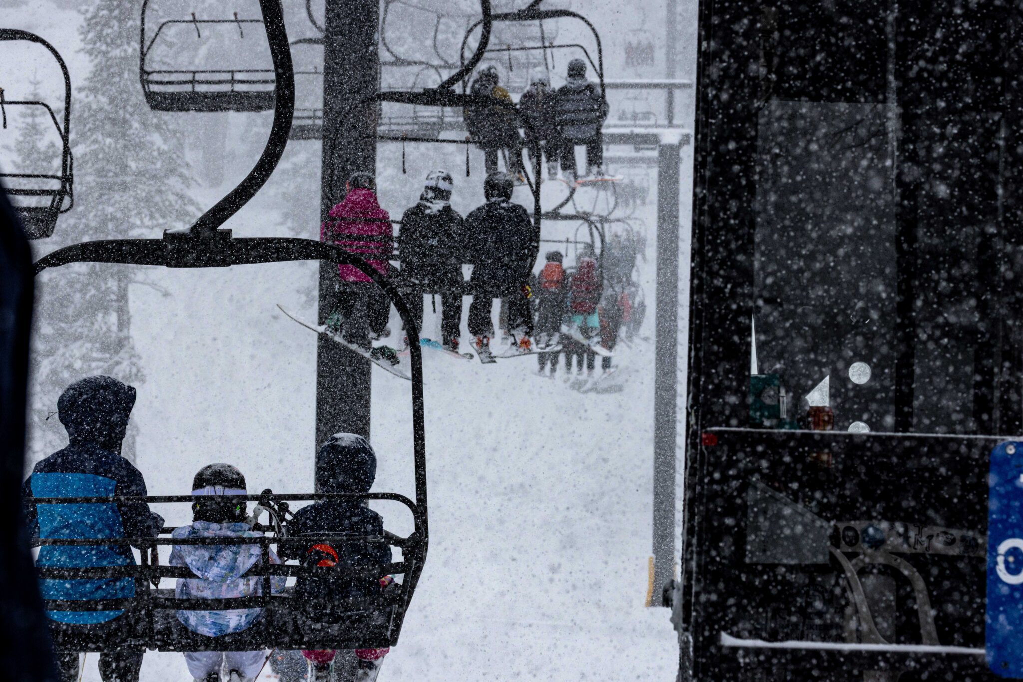 Skiers and riders on a chairlift on a storm day
