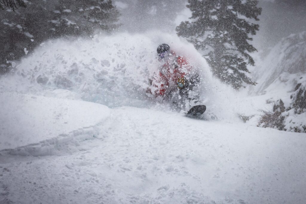 Snowboarder turns on powder on February 16, 2026.
