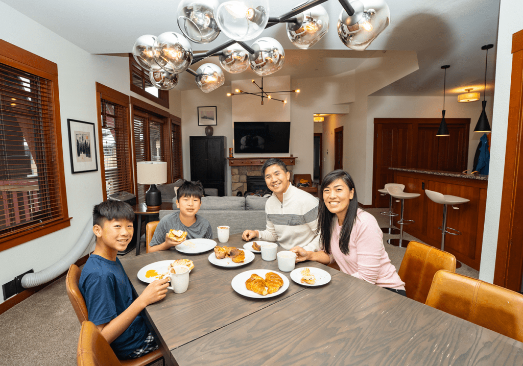 Family of four sitting down for breakfast at their in room dining room at Palisades Tahoe